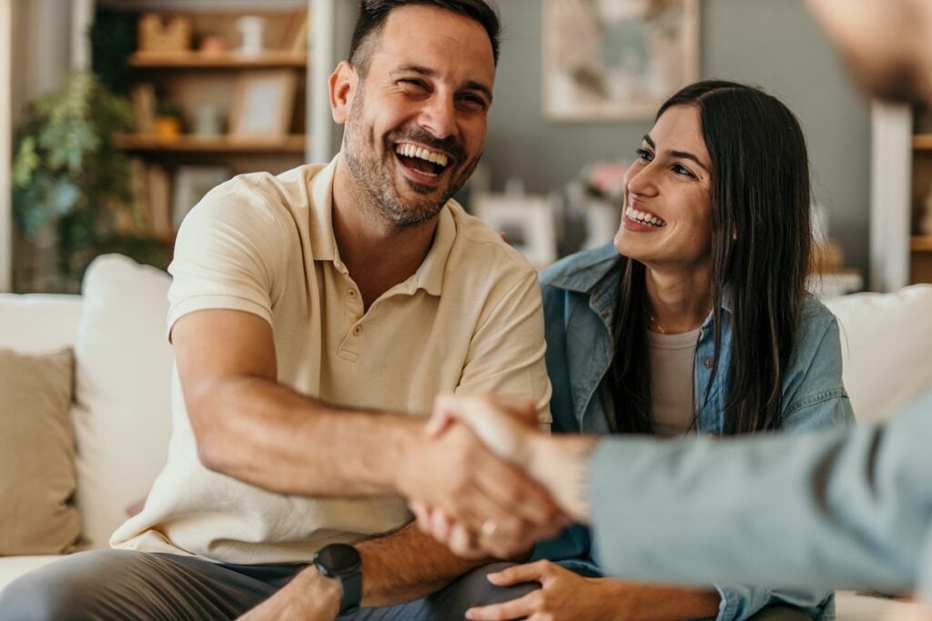 Young couple shakes hands with contractor happy