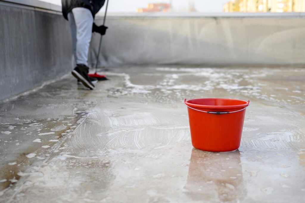 Professional commercial roof cleaner with red bucket