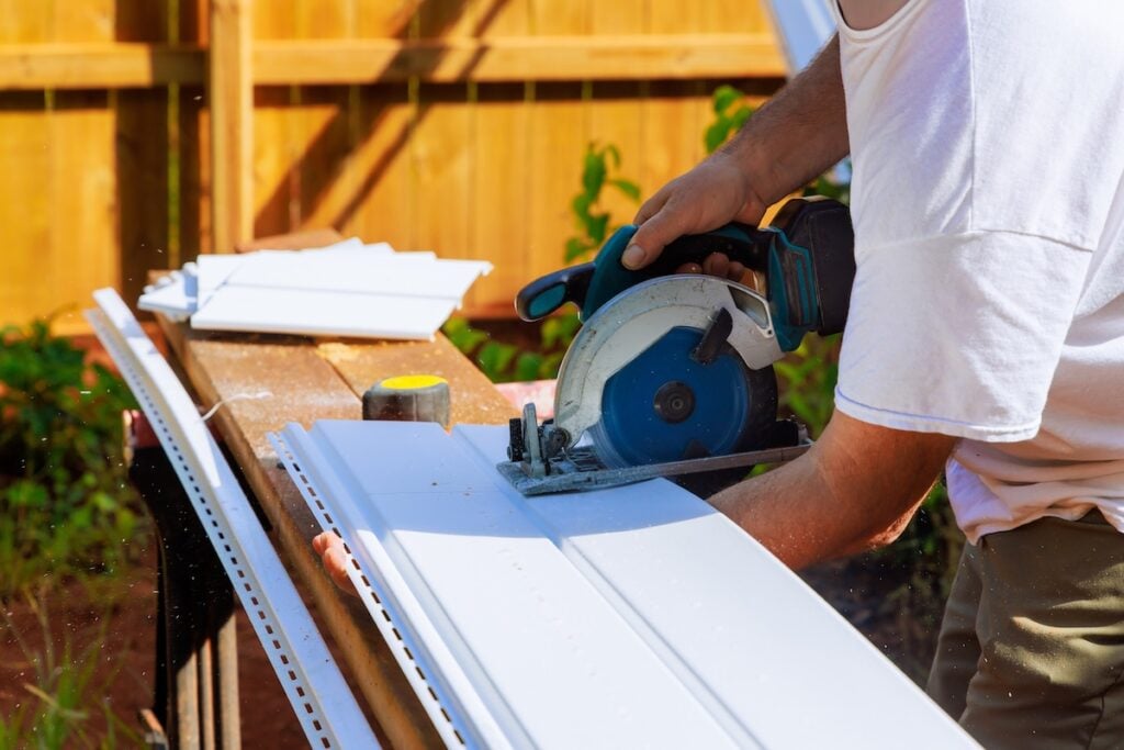 Prior to installing vinyl siding panels on craftsman facade, vinyl siding panels are cut to desired sizes during construction