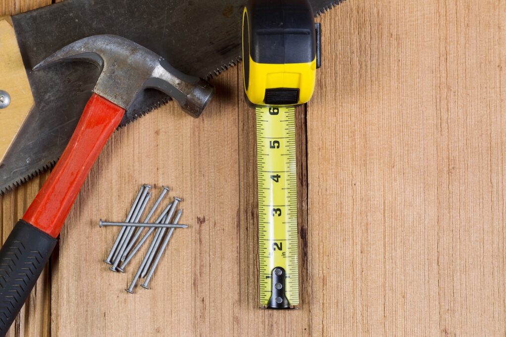 measuring tape and hammer on table