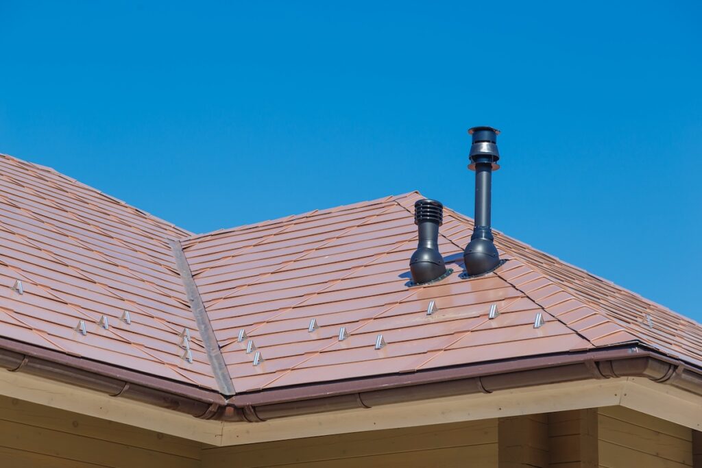 Plastic Fume Hood and exhaust pipe on Residential Building with copper Roof.