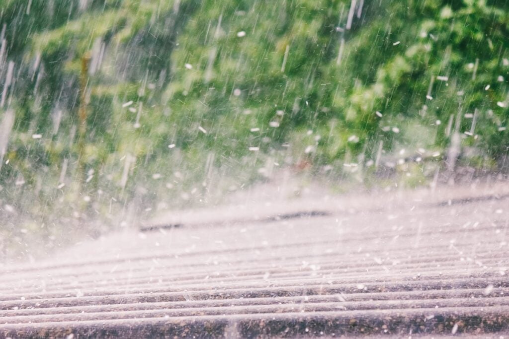 summer rain with hail falls on the roof coated metal