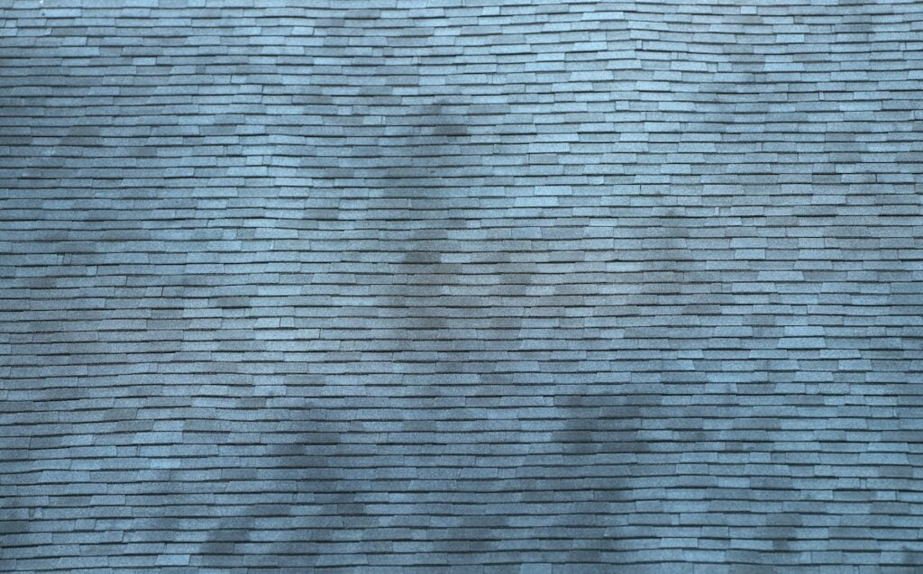 close up on old roof shingles with black streaks