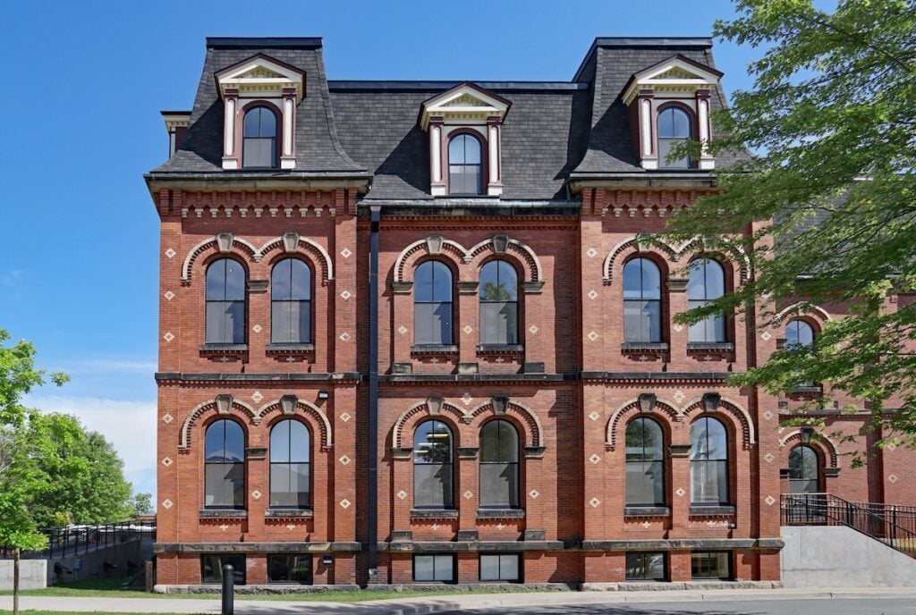 large old fashioned brick building with mansard roof 