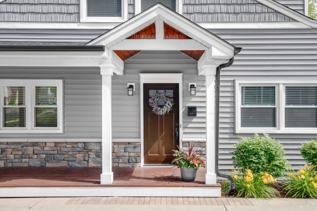 gray vinyl siding installed on home with wooden door