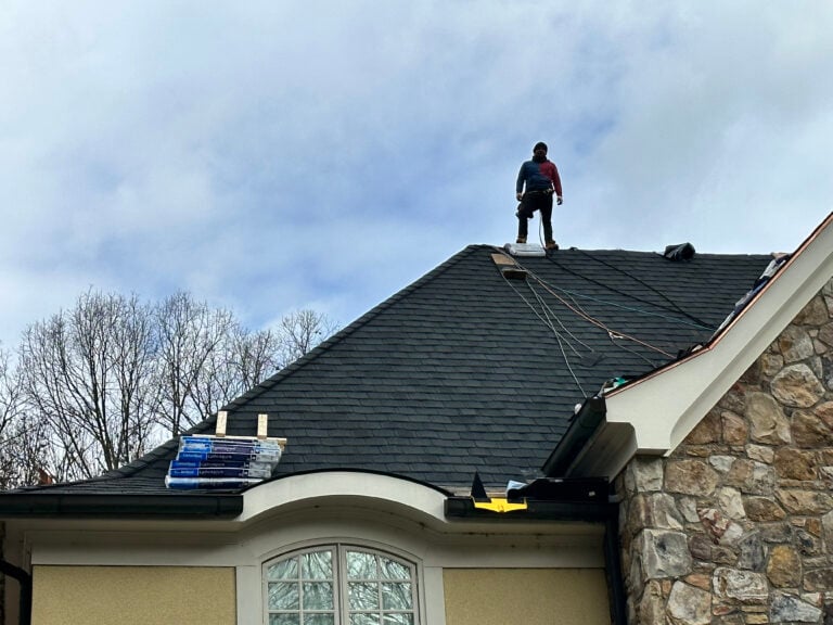 residential roof replacement services Springfield Roofing worker on top of shingles roof