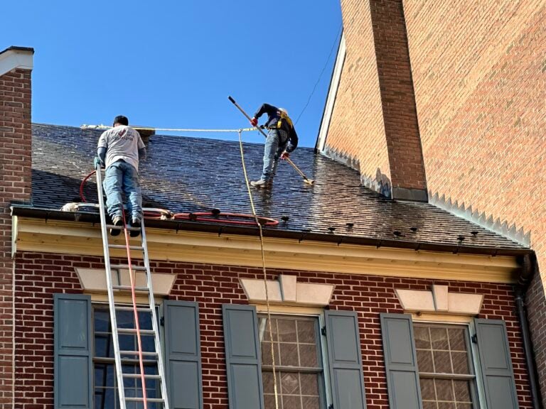 roofing maintenance programs two workers on top of tile roof