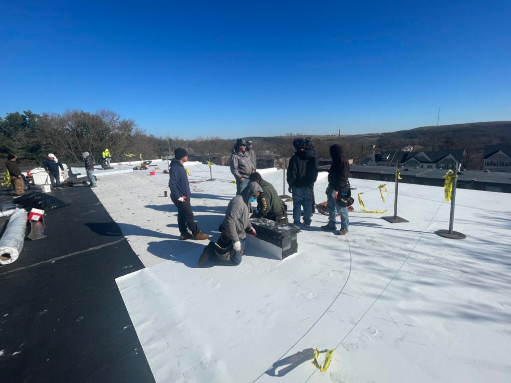 commercial roofing maintenance Springfield workers repairing flat white roof