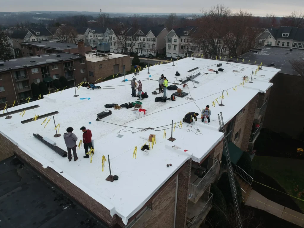 commercial roof maintenance checklist Springfield Roofing workers on top of white TPO roof