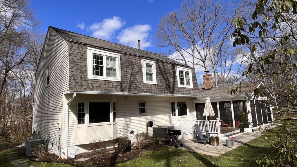 residential roof replacement services small house with shingles roof and white frame windows