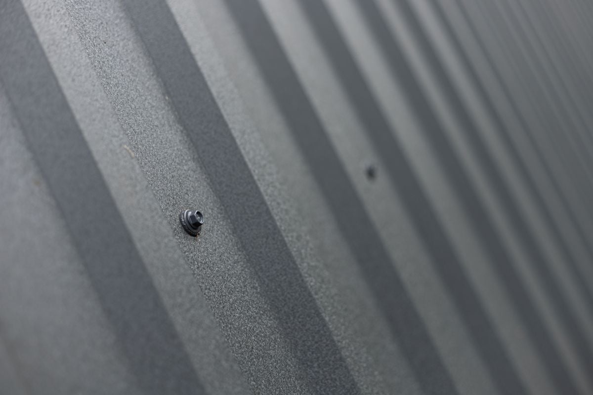 Roofing from galvanized metal profiled sheet, metal self-tapping screw with a press washer, fastening close-up