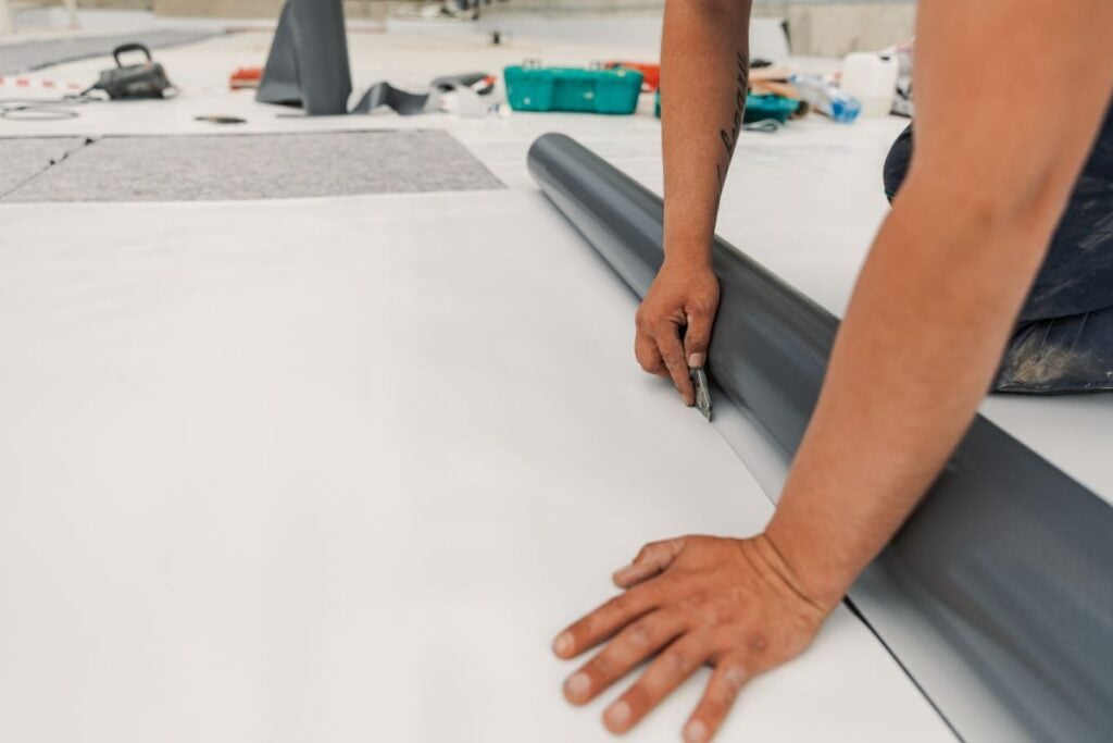 Worker specialized in mounting PVC membranes, TPO in the process of installing a water resistant system
