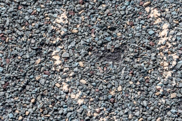 Macro of hail damage on a shingle residential roof circled with a chalk outline during a home inspection.
