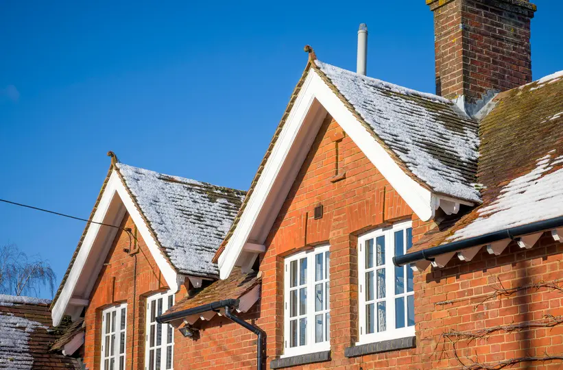 Old house with snow on pitched roof